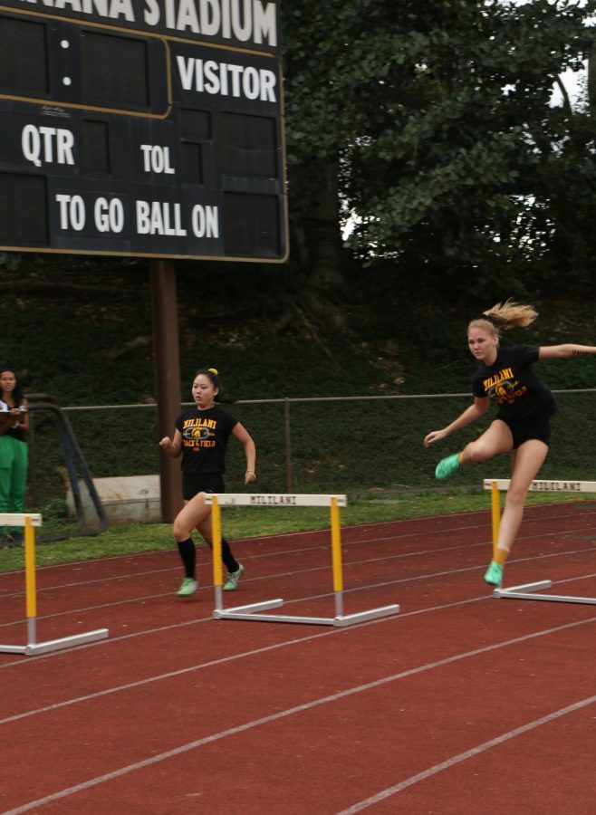 Caralyn Yamasaki (12) and Kendall scott (11) compete in girls 300 meter hurdles.